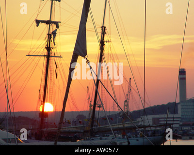 Hohe Schiffsmasten vor dramatischem orangenem Sonnenuntergang über Auckland Harbour, Nordinsel, Neuseeland Stockfoto