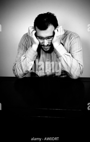 Depressive Menschen Kopf in Händen an einem Tisch sitzen Stockfoto