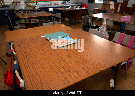 Schulbücher und englische Lehrbücher sitzen auf Tabellen in eine leere primäre Schule Klassenzimmer Belfast Nordirland Vereinigtes Königreich Stockfoto