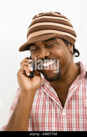 Afro-Amerikaner Mitte erwachsenen Mannes trägt Hut und Lächeln während des Gesprächs auf Handy Stockfoto