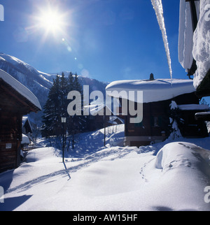 Pralinenschachtel Winter Blick mit dicken Schnee auf Chalet Dächer & großen Eiszapfen hängen in Biel Dorf das Goms-Tal der Schweiz Stockfoto