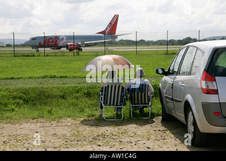 Älteres Ehepaar beobachten Flugzeug Land an Manchester Flughafen internationale Sicht unkenntlich ankommen sehen Flugzeugbeobachter GB Stockfoto