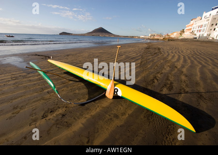 Ein gelbes Kanu, das am frühen Morgen auf Teneriffa auf den Kanarischen Inseln am Sandstrand liegt Stockfoto