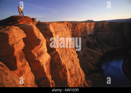 Koppeln Sie stehen über Horseshoe Bend am Colorado River bei Sonnenuntergang in der Nähe von Glen Canyon und Page, Arizona USA Stockfoto