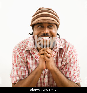 Afro-Amerikaner Mitte erwachsenen Mannes trägt Hut und lächelte Viewer mit Händen zusammen Stockfoto