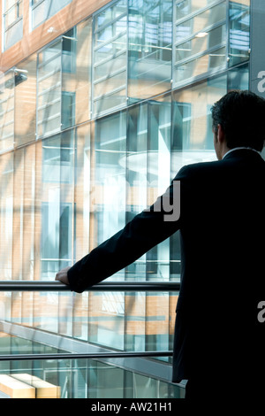 Mann am Fenster in einem Bürogebäude Stockfoto