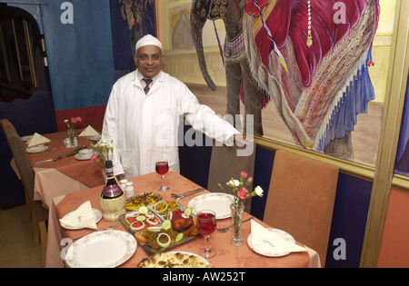 Restaurateur begrüßt Sie in einer Tabelle in seinem Curry Haus Stockfoto