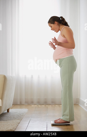 Schwangere Frau auf Waage Stockfoto