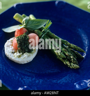 Spargel mit Melonenkugeln, Ziegenkäse und Basilikum auf einen blauen Teller Stockfoto