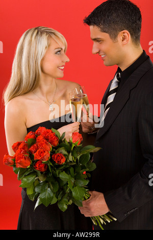 Junges Paar Toast Manan erhöhen hält Strauß Rosen sind beide Lächeln und sahen einander Seitenansicht Stockfoto