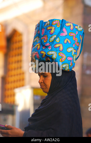 Frau mit ihr Einkaufen auf dem Kopf in Assuan berühmten Souk, einer der buntesten Märkte in Ägypten Stockfoto