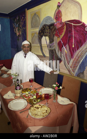 Restaurateur begrüßt Sie in einer Tabelle in seinem Curry Haus Stockfoto