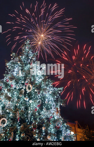 Beleuchtete riesige Outdoor-Weihnachtsbaum und Feuerwerk platzt oben in den Nachthimmel, die Silvester feiern Stockfoto