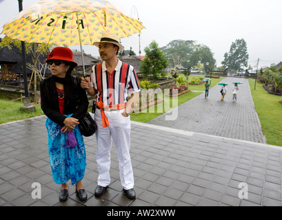 Touristen mit Sonnenschirmen auf der Pura Besakih Tempel Bali Indonesien Stockfoto