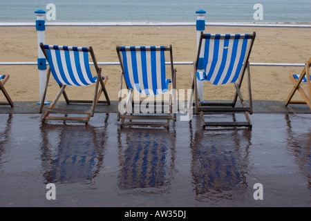 Liegestühle am Strand bei schlechtem nassem Wetter in Weymouth, Dorset Stockfoto