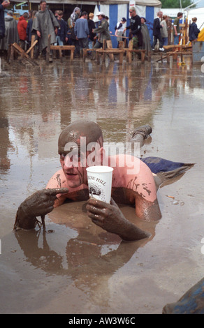 Glastonbury 1998 Mann Verlegung im Schlamm genießen Apfelwein aus dem Most-bus Stockfoto