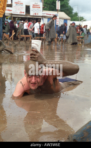 Glastonbury 1998 Mann Verlegung im Schlamm genießen Apfelwein aus dem Most-bus Stockfoto