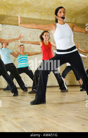 Eine Gruppe von Frauen, die das Training mit Fitness-Trainer in der Turnhalle Fokus auf die Frau in weißem Hemd niedrigen Winkel Ansicht Stockfoto