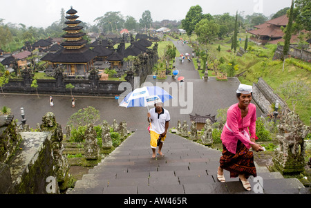 Lokale balinesischen Menschen tragen Regenschirme Treppenstufen bis zu der Pura Besakih Tempel Bali Indonesien Stockfoto