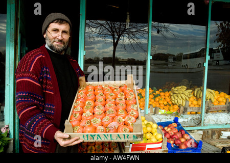 Ein Obst-Shop-Betreiber mit einem Tablett mit frischen Produkten vor seinem Geschäft in der Türkei. Stockfoto