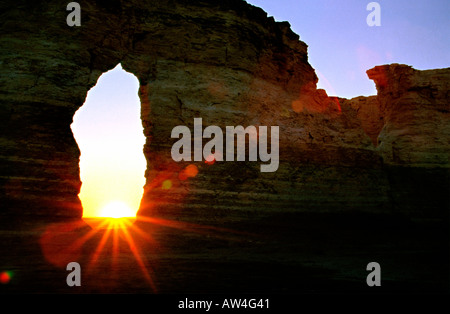 Untergehende Sonne durch das Schlüsselloch der Denkmal-Felsen im westlichen Kansas. Stockfoto