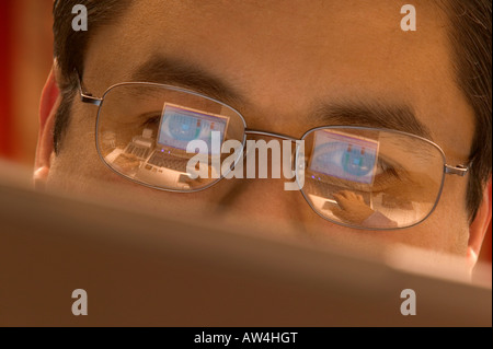 Laptop-Bildschirm spiegelt sich in den Gläsern ein Mann arbeitet. Stockfoto