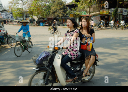 Zwei junge Frauen fahren rund um ihr Motorrad auf genießen Sie einen Einkaufsbummel