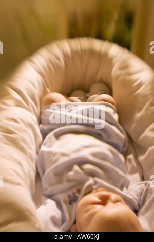 Babyfüße in einem Liegekorb im frühen Morgenlicht. Stockfoto