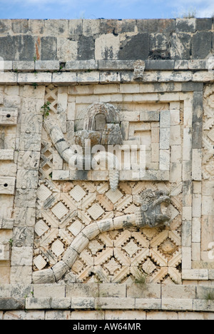 Uxmal, Mexiko - 19 Jan 2007: Krabbelnde Schlangenschnitzerei mit kunstvollem Gitter, Casa de las Monjas oder dem Nonnenkloster Stockfoto