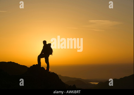 Ein Walker auf Wirbel Howe bei Sonnenuntergang Seenplatte UK Stockfoto