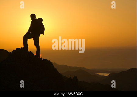 Ein Walker auf Wirbel Howe bei Sonnenuntergang Seenplatte UK Stockfoto