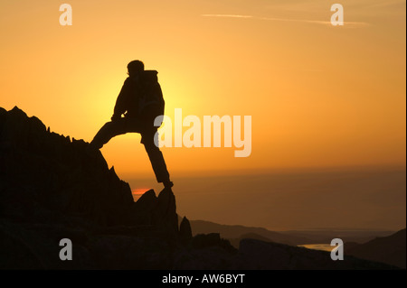 Ein Walker auf Wirbel Howe bei Sonnenuntergang Seenplatte UK Stockfoto