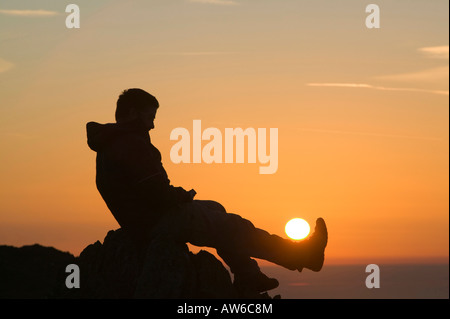 Ein Walker auf Wirbel Howe bei Sonnenuntergang Seenplatte UK Erfassung der Kraft der Sonne Stockfoto