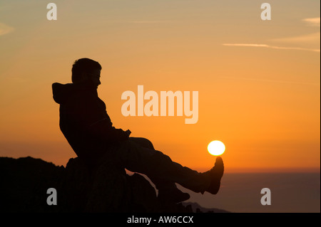 Ein Walker auf Wirbel Howe bei Sonnenuntergang Seenplatte UK Erfassung der Kraft der Sonne Stockfoto