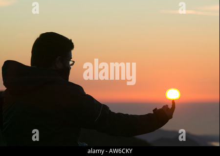 Ein Walker auf Wirbel Howe bei Sonnenuntergang ändern Seenplatte UK Erfassung der Kraft der Sonne der tipping Point an den katastrophalen Klimawandel Stockfoto