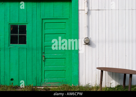 Die Seite eines Gebäudes mit einer leuchtend grünen Tür auf Manitoulin Island, Ontario, Kanada. Stockfoto