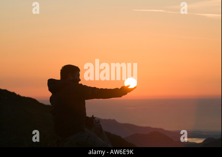 Ein Walker auf Wirbel Howe bei Sonnenuntergang Seenplatte UK Erfassung der Kraft der Sonne Stockfoto