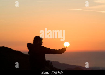 Ein Walker auf Wirbel Howe bei Sonnenuntergang ändern Seenplatte UK Erfassung der Kraft der Sonne der tipping Point an den katastrophalen Klimawandel Stockfoto