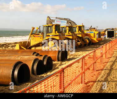 Baufahrzeuge auf Boscombe Strand, Bournemouth, Großbritannien, Leben von Fußgängerzone von orange Netz. Stockfoto