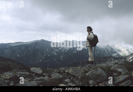 Frau steht auf Bezbog Gipfel im Hintergrund Strazite Mnt in Nationalpark Pirin Bulgarien Stockfoto