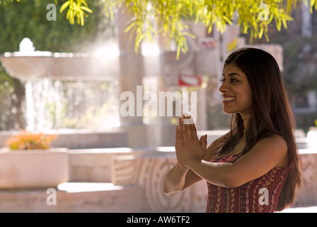 Indische Frau beten vor Brunnen Stockfoto