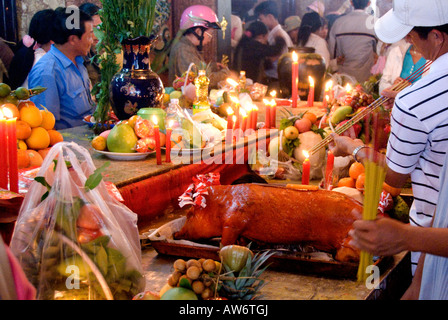 Ein Pilger bietet ein gebratenes Schwein in dem Tempel Dame Xu, Nui Sam während Tet, in der Hoffnung auf Glück und Wohlstand im neuen Jahr Stockfoto