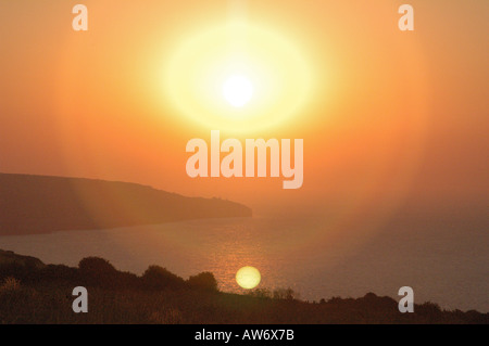 Sonnenaufgang über dem Dorset Küste Großbritannien mit der Sonne im Meer reflektieren Stockfoto