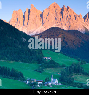 St. Magdalena, Val di Funes, Trentino-Alto Adige, Italien. Blick auf die Geisler-Peaks bei Sonnenuntergang, Dorfkirche im Vordergrund. Stockfoto