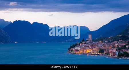 Malcesine, Veneto, Italien. Blick ins Dorf über das tiefblaue Wasser des Gardasees, Dämmerung. Stockfoto