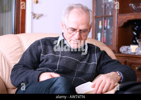 Senior Mann liest ein Buch (einschlafen während des Lesens) Stockfoto