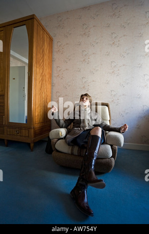 Eine zweifelhafte junge Dame in einem altmodischen Zimmer. Jeune Femme verneinend Dans Une Chambre d'Hôtel Démodée. Stockfoto