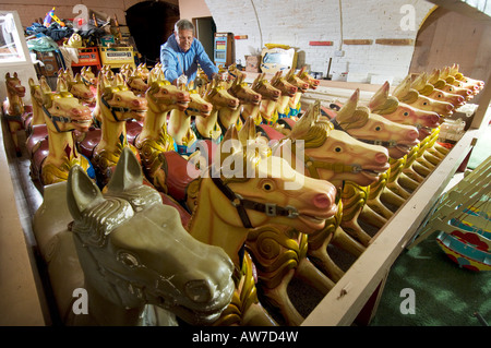 Kirmes Karussell Pferde Lagerung mit Winter fertig aus der Saison Reparaturen. Stockfoto