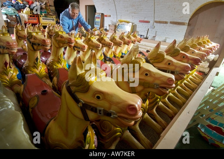 Kirmes Karussell Pferde Lagerung mit Winter fertig aus der Saison Reparaturen. Stockfoto