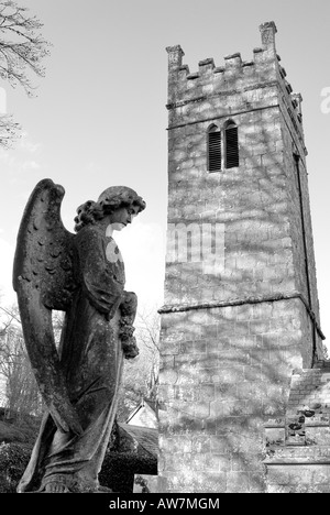 Der Turm der Hl. Dreifaltigkeit-Kirche in Gidleigh auf Dartmoor mit einem steinernen Engel im Vordergrund in Monochrom Stockfoto